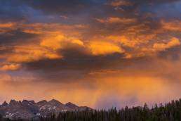 Mountain landscape with dramatic sunset skies, showcasing vibrant orange and purple hues, relevant to Colorado's natural beauty and pest control environment.