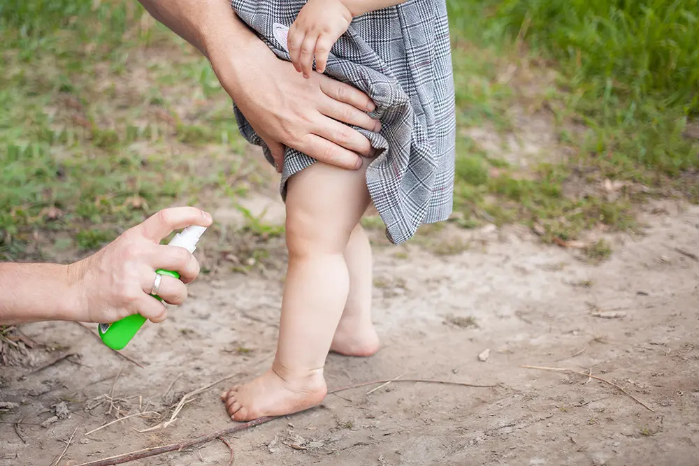 Spraying a baby's leg for mosquito protection from Western Equine Encephalitis and West Nile Virus in Colorado