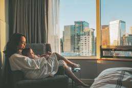 A mother relaxing with her baby in a clean hotel room, emphasizing the need for pest control in the hospitality industry.